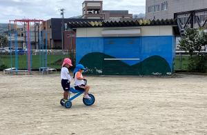 三輪車の後ろに年少児をのせる画像