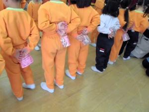 プレゼントをこっそり後ろに隠している画像