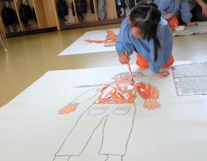 等身大の絵に色を塗る画像
