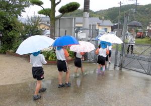 傘をさして出かける画像