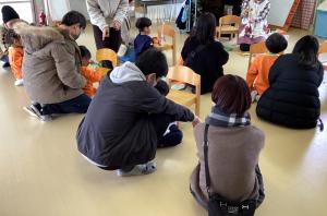 おうちの方に見守られながら画用紙を切る画像う